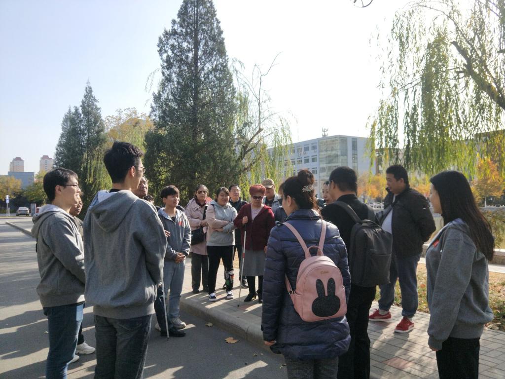 志愿者为盲人朋友讲解校园建筑